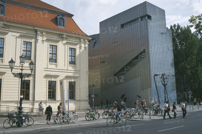 GERMANY, Berlin, Visitors at entrance to the Jewish Museum designed by Polish architect Daniel Libeskind situated beside traditional building with bicycles chained up outside.