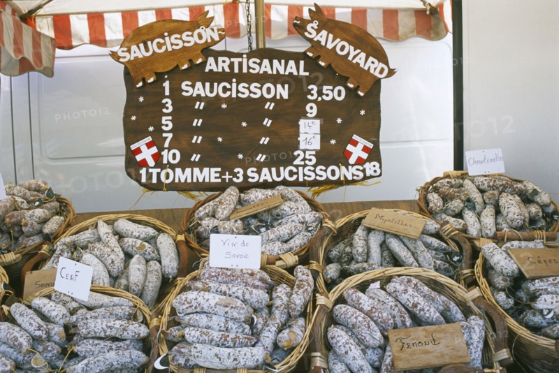 FRANCE, Rhone Alps, Haute Savoie, Samoens.  Baskets of different flavoured pork sausages for sale on market stall.