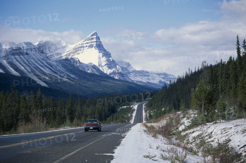 CANADA, Alberta, Banff National Park , Car on Trans-Canada highway through snow covered landscape.