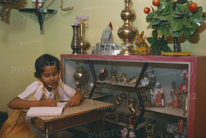 INDIA, Madhya Pradesh, Education, Ten year old girl doing homework in sitting room of middle class home.