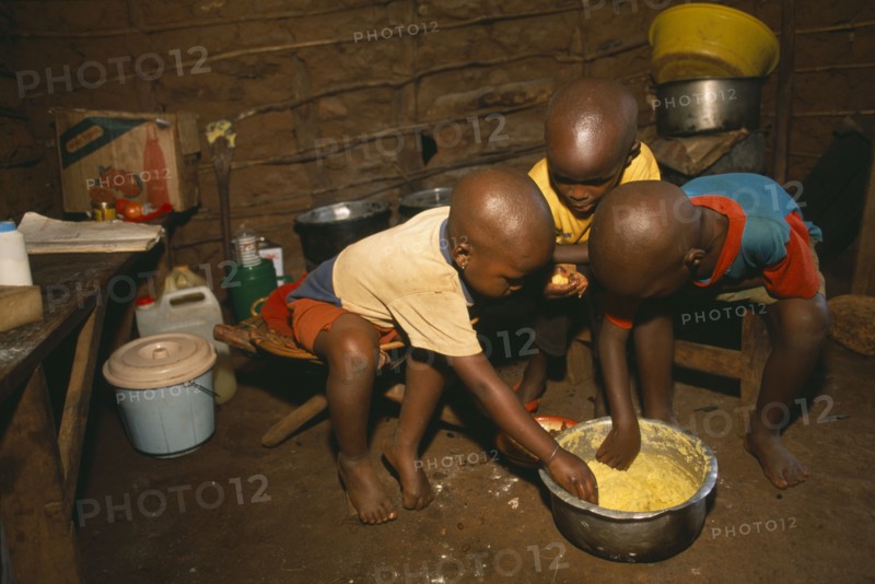 TANZANIA, West, Great Lakes Region, Refugee children eating maize porridge.