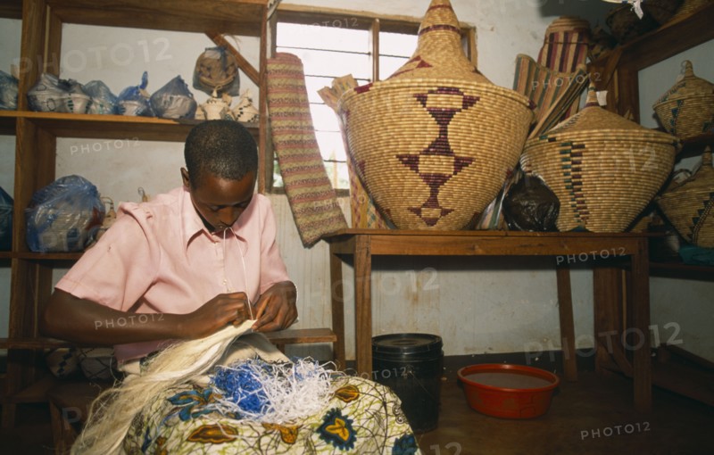 TANZANIA, West, Great Lakes Region, Refugee making traditional woven baskets.