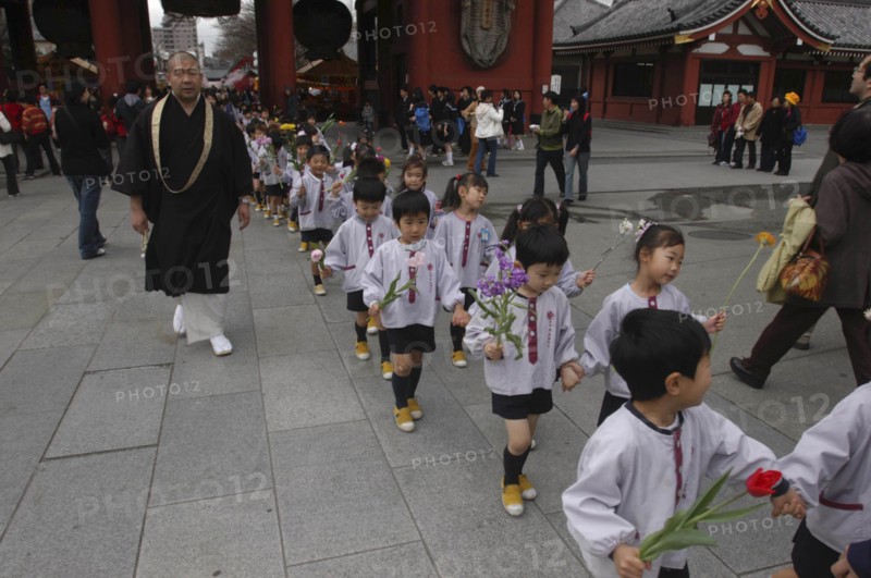 JAPAN, Honshu, Tokyo, "Asakusa. 4 year old nursery students from Senso-ji Dembo-in Nursery, carrying flowers to present to Buddha as part of his birthday celebrations, accopamied by Buddhist monk"