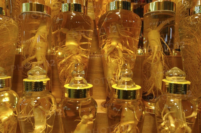 KOREA, Seoul, Namdaemun Market on a cold December night. Whole ginseng root on display in glass bottles