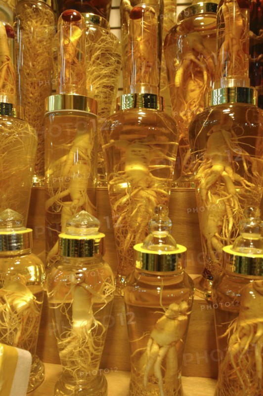KOREA, Seoul, Namdaemun Market on a cold December night. Whole ginseng root on display in glass bottles