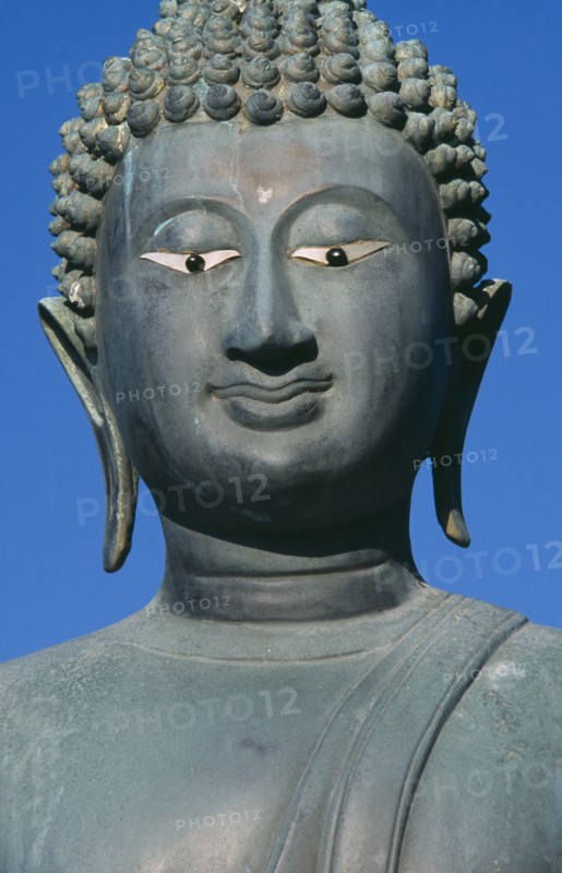 SRI LANKA, Colombo, Seema Malakaya on Beira Lake. Face of a Buddha statue against a blue sky