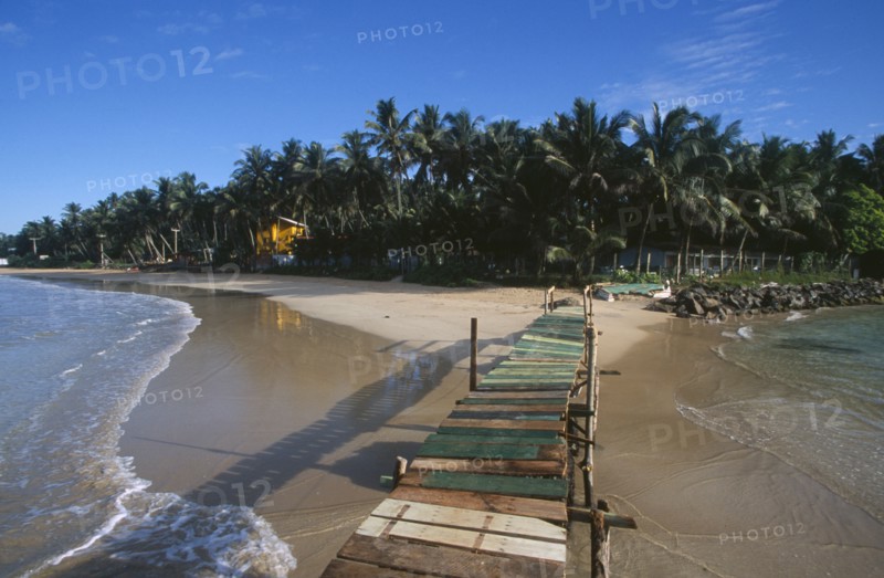 SRI LANKA, Mirissa, View along wooden jetty over the sea leading toward sandy beach