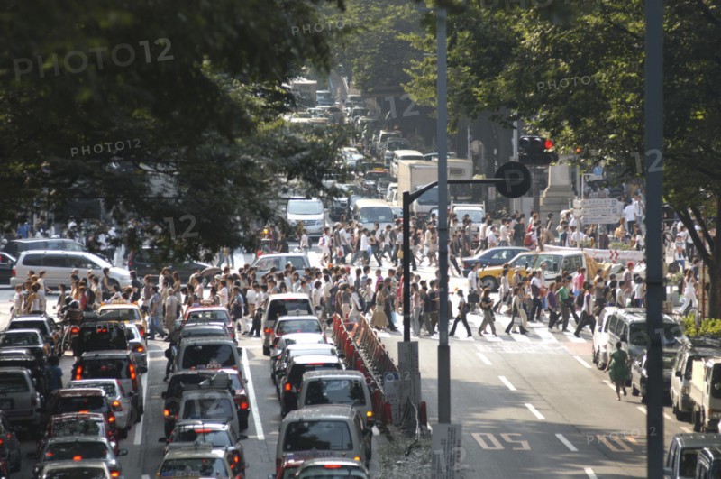 JAPAN, Honshu, Tokyo, "Harajuku. View looking up Omote-sando avenue to the intersection with Meiji-dori avenue with crowds on a pedestrian crossing, Saturday afternoon  "