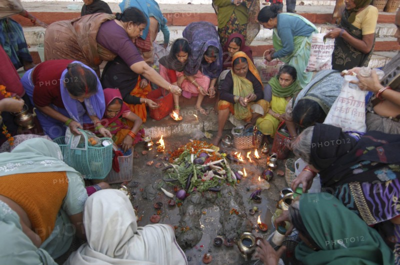 INDIA, Uttar Pradesh, Varanasi , Hindu women worship an earthen statue of Hindu God Bhim at Asi Ghat beside the Ganges River
