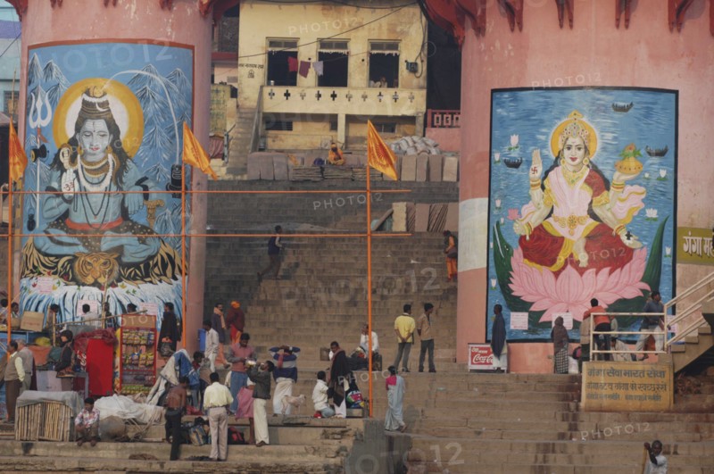 INDIA, Uttar Pradesh, Varanasi , Murals of Shiva and Parbati at Dashaswamedh Ghat with Hindu pilgrims on the steps