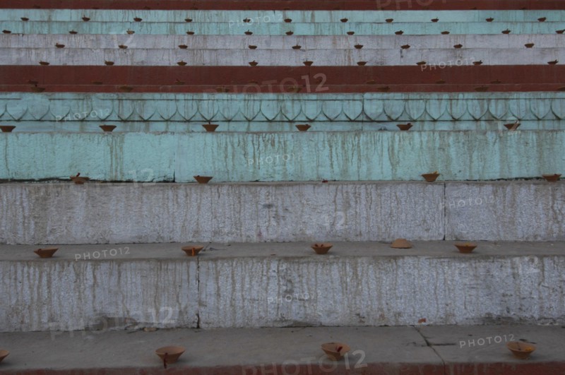 INDIA, Uttar Pradesh, Varanasi , Deep Diwali festival with close up view of oil lamps to be lit at night on steps leading down to the Ganges River