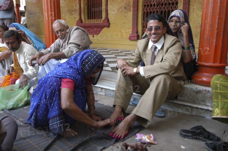 INDIA, Uttar Pradesh, Varanasi, Sankat Mochan Mandir temple. Hindu wedding with the groom getting his feet painted auspicious red as his mother sits behind him