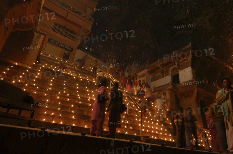 INDIA, Uttar Pradesh, Varanasi, Deep Diwali Festival. View looking up steps leading down to the Ganges River with festival goers and oil lamps
