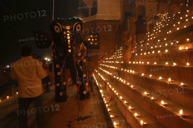 INDIA, Uttar Pradesh, Varanasi, Deep Diwali Festival with paper statue of Hindu God Ganesh on steps of ghats lined with oil lamps leading to Ganges River