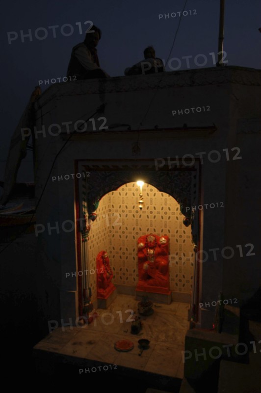 INDIA, Uttar Pradesh, Varanasi, Near Hanuman Ghat. A Hanuman Shrine on the Ganges River at night