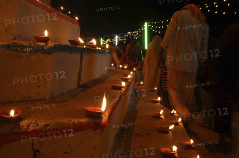 INDIA, Uttar Pradesh, Varanasi, Deep Diwali Festival. Oil lamps and crowds line the steps of the Ghats leading down to the Ganges River