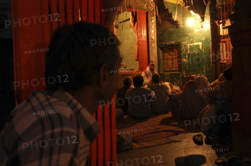 INDIA, Uttar Pradesh, Varanasi, Dasashwamedh Ghat. Hindus listen to a Bhramin pundit lecturing in a temple