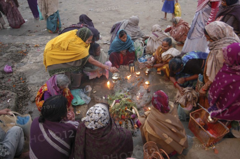 INDIA, Uttar Pradesh, Varanasi, Hindu women worshipping an earthen image of Hindu God Bhim at Asi Ghat