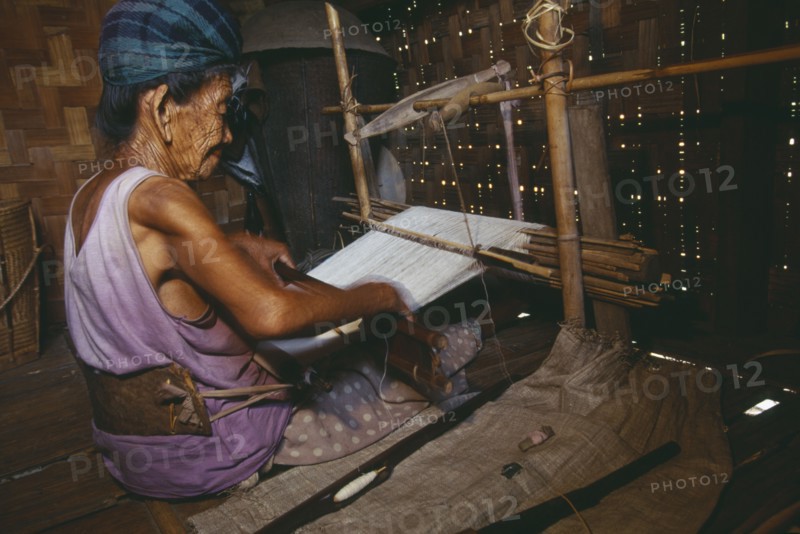 MYANMAR, Kachin State, Myitkyina, 116 year old Jinghpaw woman weaving on a back strap loom
