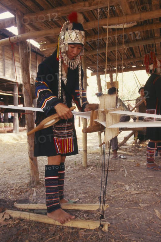 THAILAND, Chiang Mai Province, Akha woman weaving cloth on an Akha loom