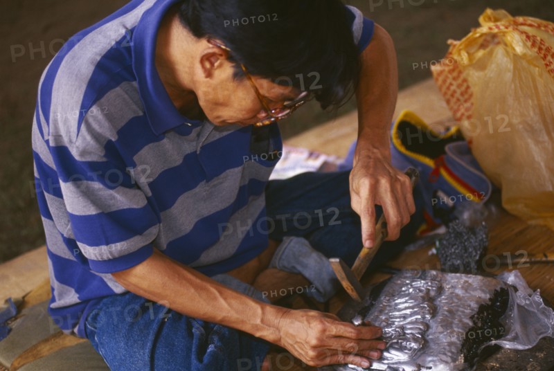 THAILAND, Chiang Mai, Wat Sri Suphan, Silversmith making repousse picture of elephants