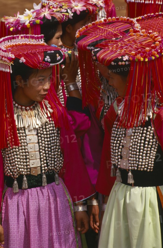 THAILAND, Chiang Rai Province, Huai Khrai, Lisu women dressed in their New Year finery turned towards each other in conversation.