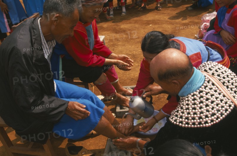THAILAND, Chiang Rai Province, Huai Khrai, New Year. Lisu people paying respects to their elders by putting new socks on their feet