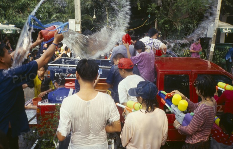 THAILAND, Chiang Mai, Songkran aka Thai New Year. Revellers in a pickup truck attempting to catch some of the water thrown at them