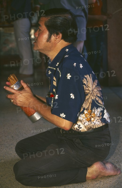 THAILAND, Chiang Mai, Chinese New Year. Worshipper at a Chinese temple during the New Year