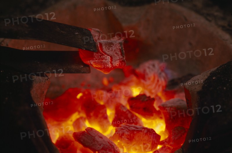 THAILAND, General, Close up of glowing hot coals and tongs in a hibachi Thai charcoal brazier