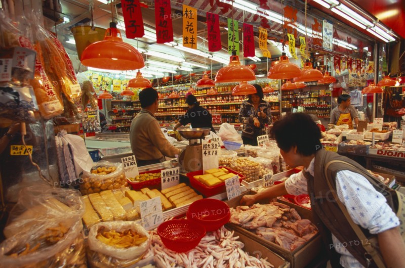 CHINA, Hong Kong, "Wanchi market interior with display of variety of food products, customers and staff."
