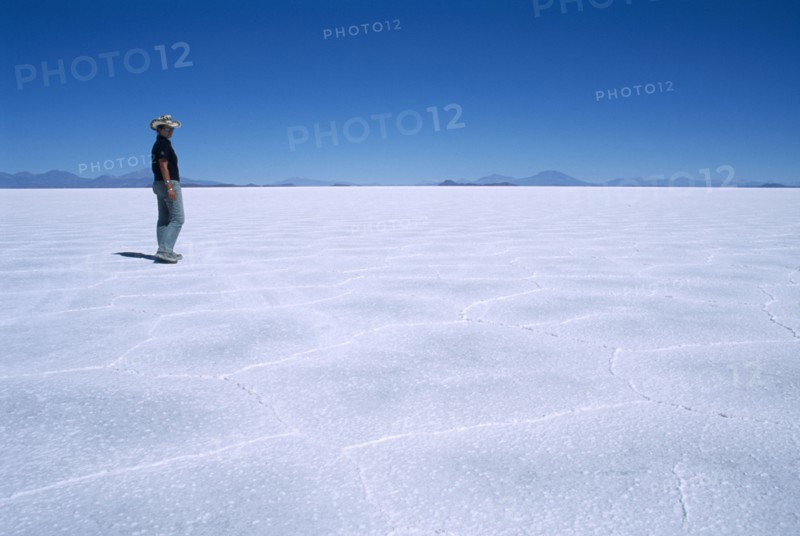 BOLIVIA, Altiplano, Potosi, Salar de Uyuni.  Person walking across vast expanse of salt lake.