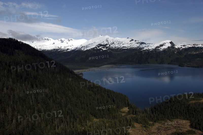USA, Alaska, Prince William Sound, View over tree covered slopes and waters toward snow capped mountain peaks on the other side