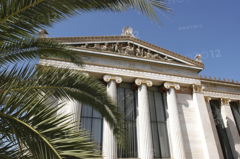 GREECE, Athens, Angled view of the National Academy columned facade partially obscured by palm fronds
