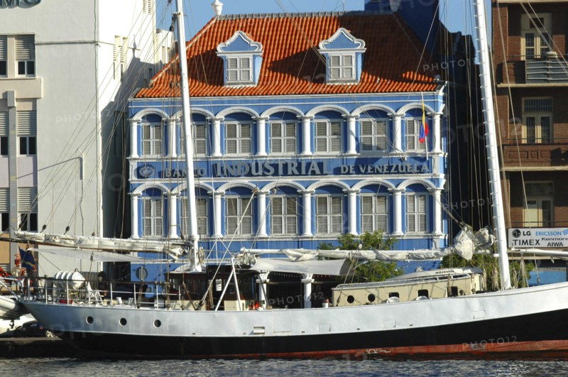 WEST INDIES, Dutch Antilles, Curacao, Willemstad harbour front bank with boat moored in front