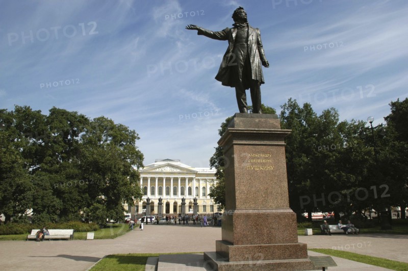 RUSSIA, St Petersburg, Statue in park with the Mikhailovsky Palace and Russian Museum in the distance