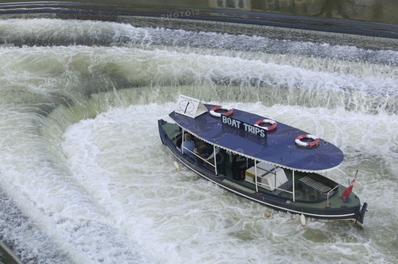 ENGLAND, Bath, A pleasure boat in the weir beneath Pulteney Bridge.