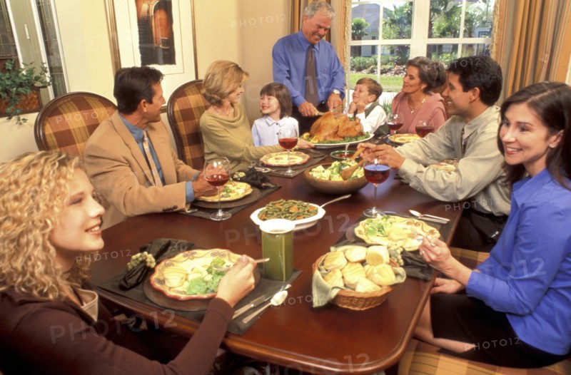 USA, People, Family eating a meal of roast turkey at the table