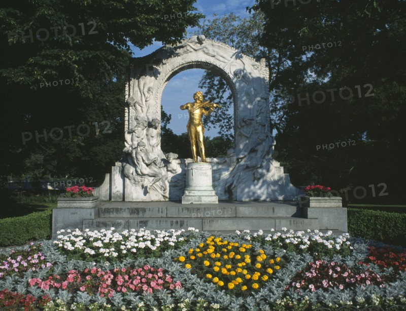 AUSTRIA, Vienna, City Park. Johan Strauss statue with flower beds in the foreground