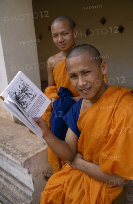 LAOS, Vientiane, Young Buddhist monks with book.