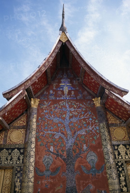 LAOS, Luang Prabang, Wat Xieng Thong.  Ornate temple exterior with Tree of Life mosaic and gold decoration.