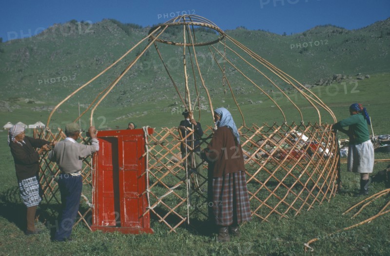 CHINA, Xinjiang, Altai Region, "Kazakh nomads building kigizuy, erecting circular frame and doorway."