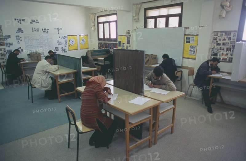 LIBYA, Benghazi, Students sitting an English exam. All male and one female.