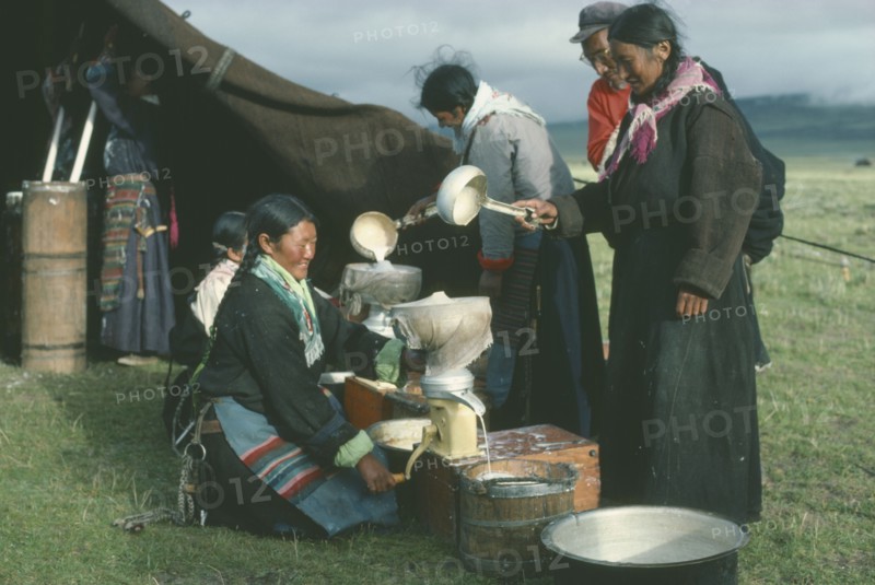 TIBET, People, Tibetan nomad women on the high grasslands with cream seperator brought by travelling salesman.