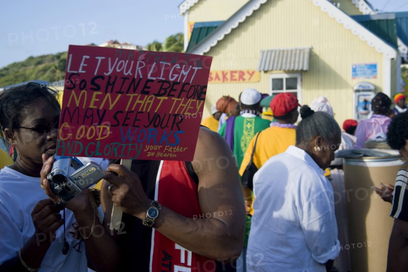 WEST INDIES, St Vincent & The Grenadines, Union Island, Couple looking at their video camera playback amongst the Baptist congregation in Clifton at Easter morning harbourside service for those lost at sea