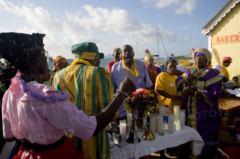 WEST INDIES, St Vincent & The Grenadines, Union Island, Women handing out donated goods amongst the Baptist congregation in Clifton at Easter morning harbourside service for those lost at sea