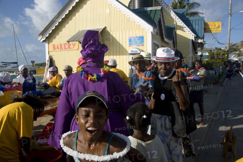 WEST INDIES, St Vincent & The Grenadines, Union Island, Woman giving blessing with Holy Water amongst the Baptist congregation in Clifton at Easter morning harbourside service for those lost at sea