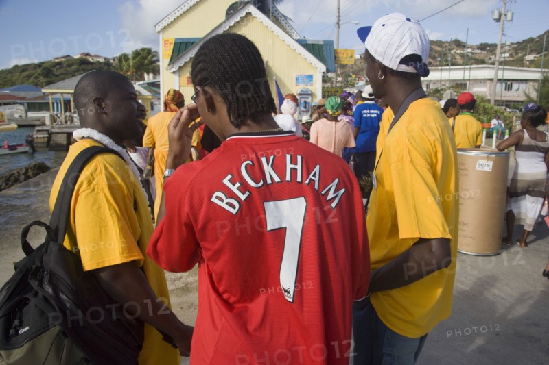 WEST INDIES, St Vincent & The Grenadines, Union Island, Men of the Baptist congregation in Clifton at Easter morning harbourside service for those lost at sea with one wearing a Beckham football shirt