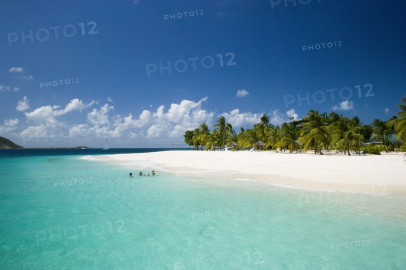 WEST INDIES, St Vincent & The Grenadines, Palm Island, The beach at Palm Island Resort with guests sitting in the water