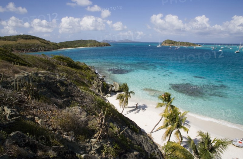 WEST INDIES, St Vincent & The Grenadines, Tobago Cays, View across the beach at Jamesby Island and moored yachts towards Canouan on the horizon